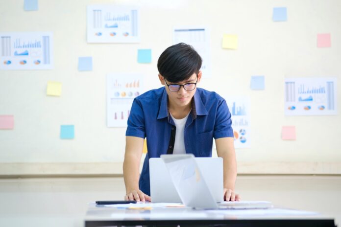 asian make looking at a computer