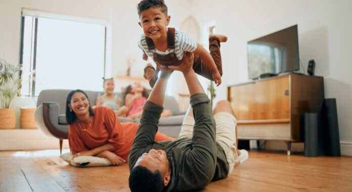 Father and son happily playing with family in background