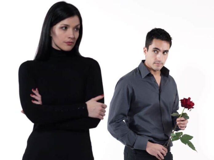 Man holding a rose and looking to a woman