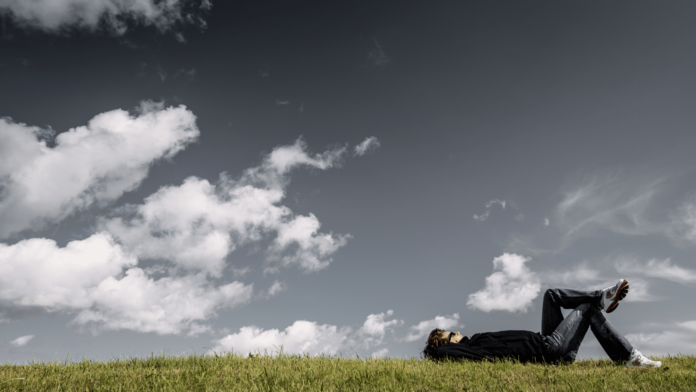 Man laying in a field having a dream