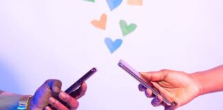 two hands holding phones messaging each other with hearts